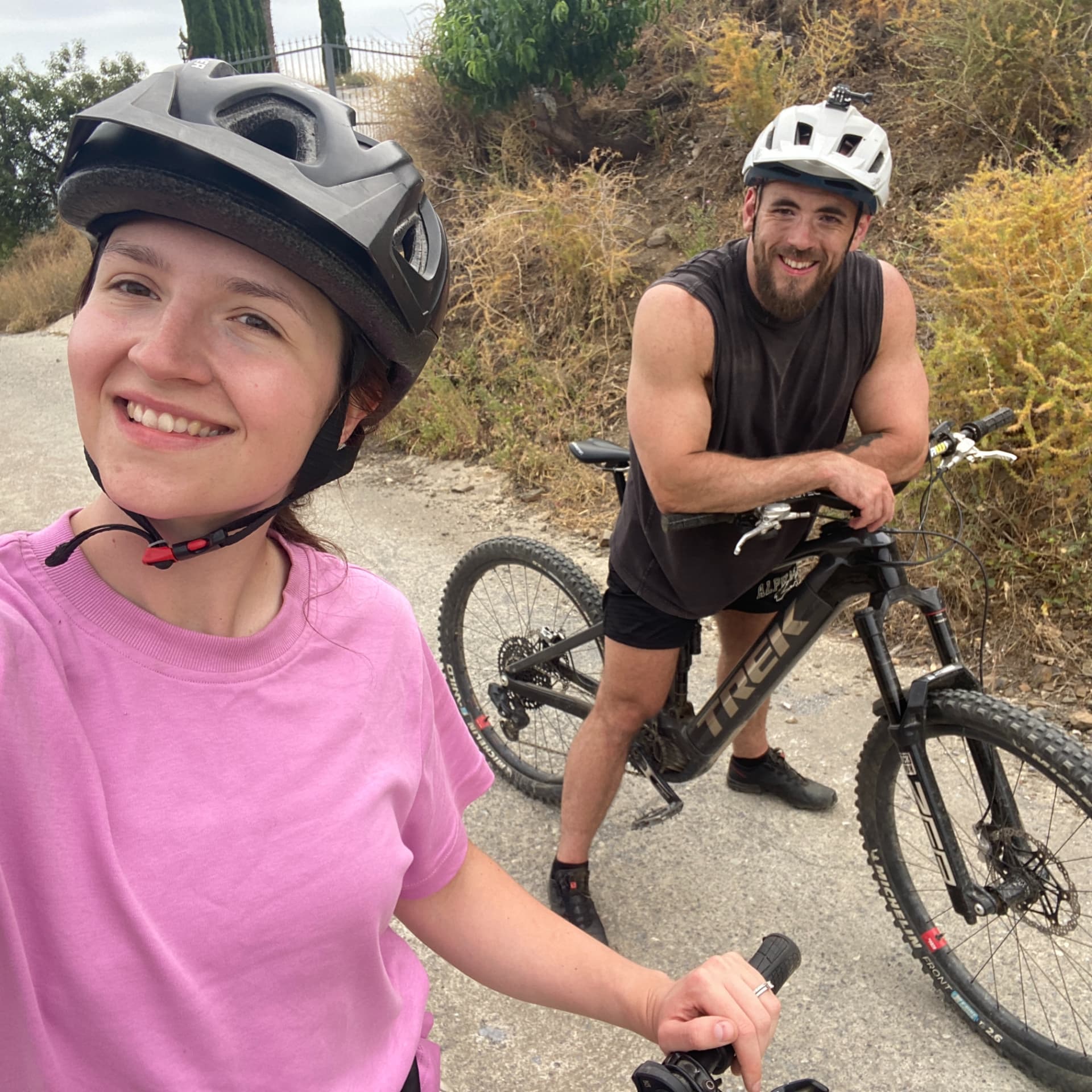 Robyn Anderton in a cycling helmet on a bike trail with her husband behind her